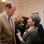 Phyllis Kornicker speaking to Bill Bradley with other people behind them.